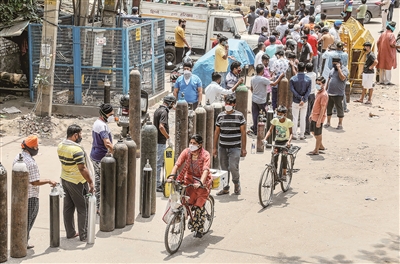 近期，印度新冠疫情形勢愈發(fā)嚴峻，數(shù)量激增的患者讓當?shù)蒯t(yī)療系統(tǒng)承受巨大壓力，部分醫(yī)院要求患者自帶氧氣瓶入院。這是4月23日，新德里地區(qū)患者家屬持空氧氣瓶排隊等待充氧。  （圖片來源：視覺中國）