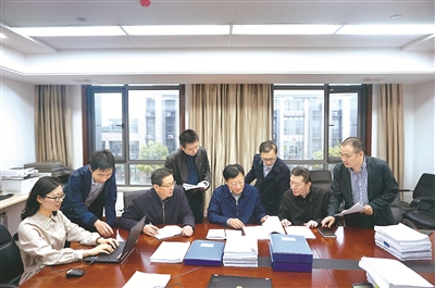 圖為安徽省紀委監(jiān)委專案組工作人員在一起省農(nóng)商行系統(tǒng)案件移送審理前，討論完善審查調(diào)查報告。  許怡然 攝