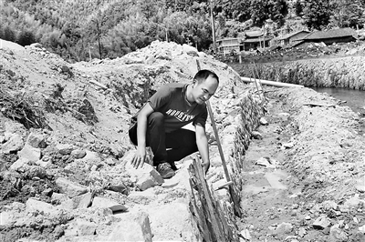 圖為福建省紀(jì)委監(jiān)委駐村第一書記詹志勛在水尾村水利基礎(chǔ)設(shè)施施工現(xiàn)場(chǎng)查看工程建設(shè)情況。