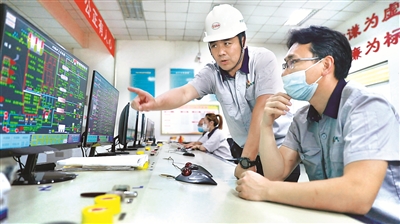 尹力軍（左）在鍋爐運行車間了解設(shè)備運行情況。（榮成市熱電燃氣集團有限公司供圖）